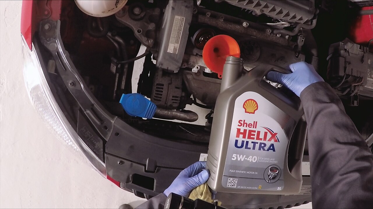 Hands pouring shell helix ultra fresh oil