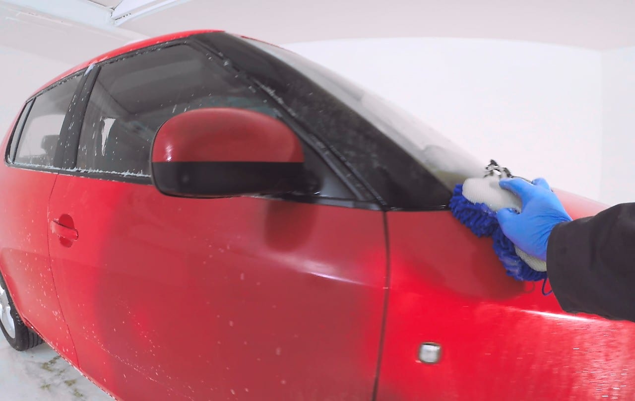 Hand washing the outside of a red car