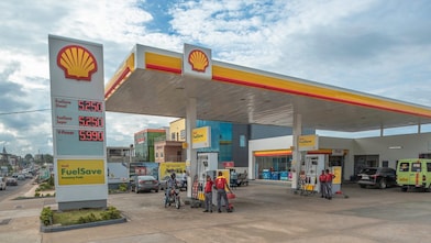 Sun rising behind a Shell station forecourt