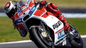 ducati superbike with rider cornering at speed on a racetrack