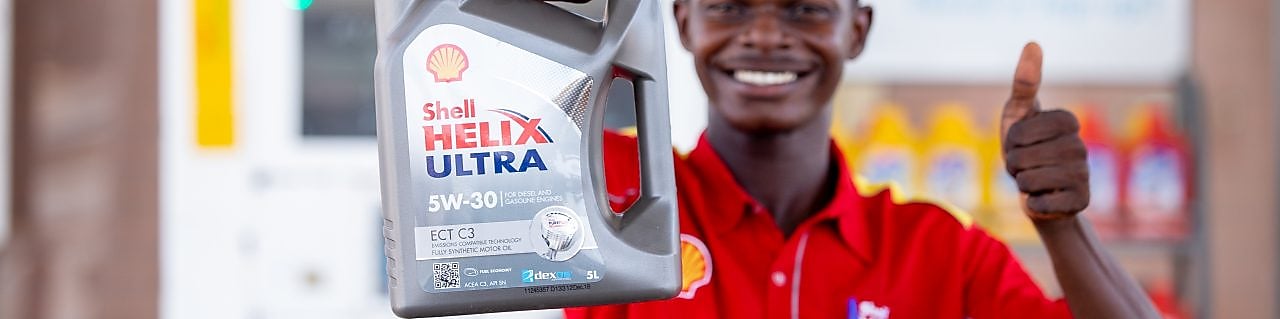 Ghanaian Customer Champion holding Shell Helix carton