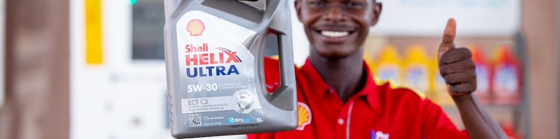 Ghanaian Customer Champion holding Shell Helix carton