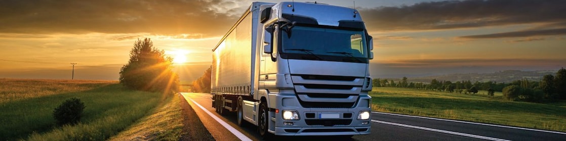 Truck on road with sunset in the background