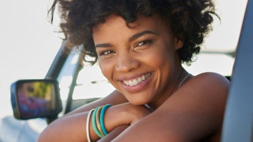 Joyful woman leaning out of car window in casual pose