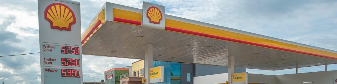 Sun rising behind a Shell station forecourt