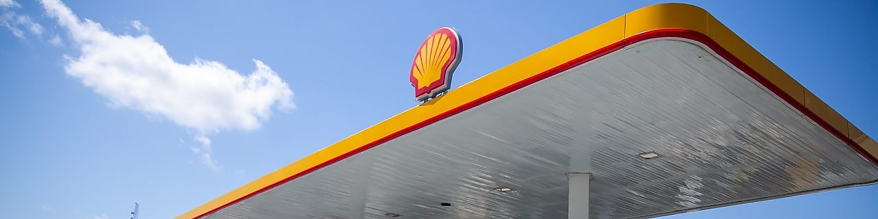 Sun rising behind a Shell station forecourt