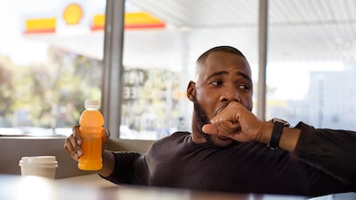 man holding drink in hand