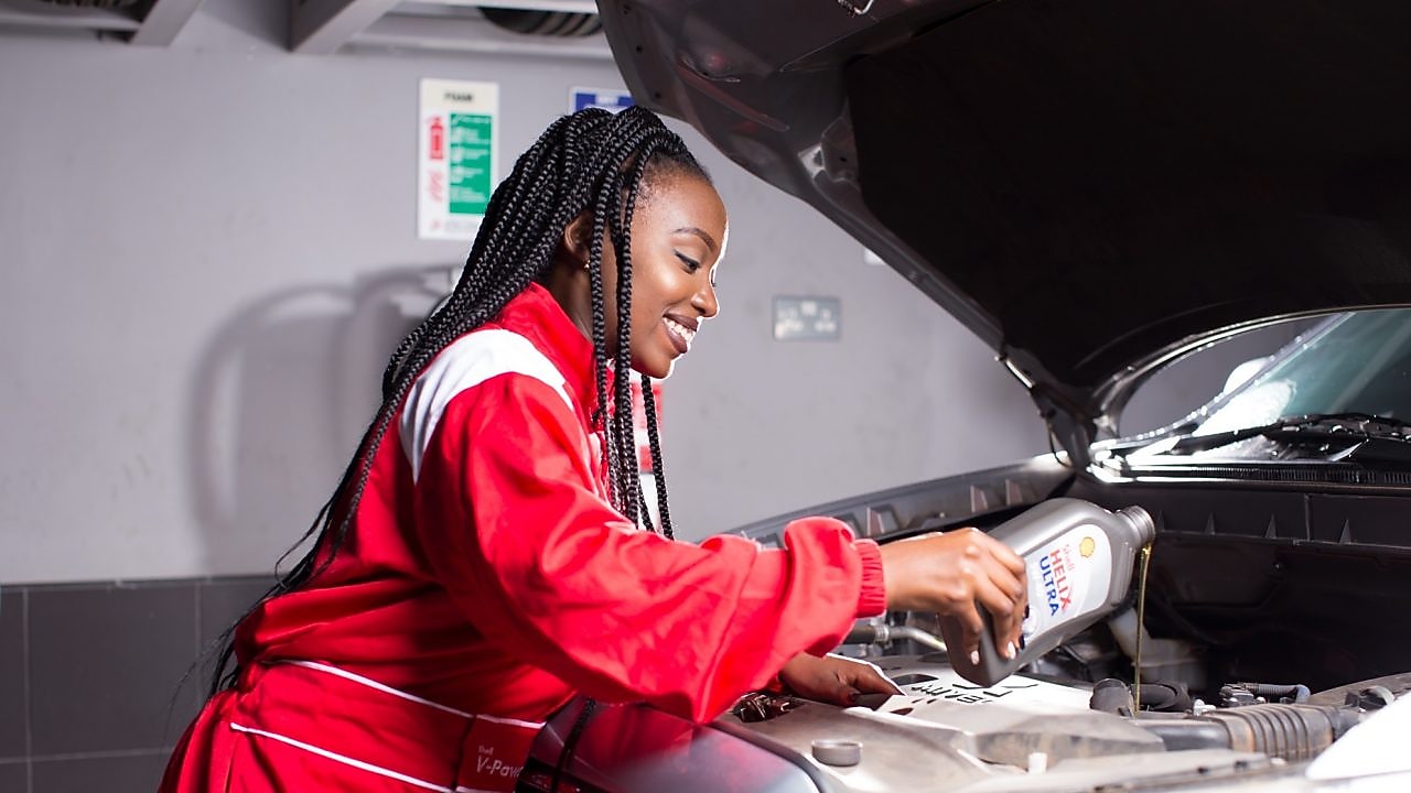 An enginner pours Shell lubricant into a car engine