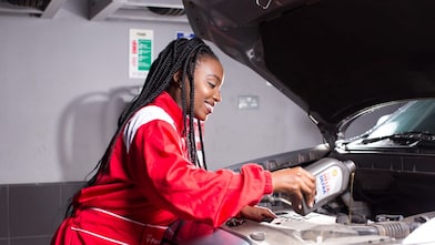 engineer pouring Shell lubricant into a car engine