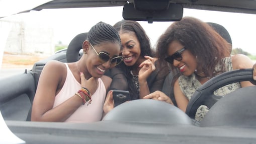 young women in car checking navigation on a smart phone