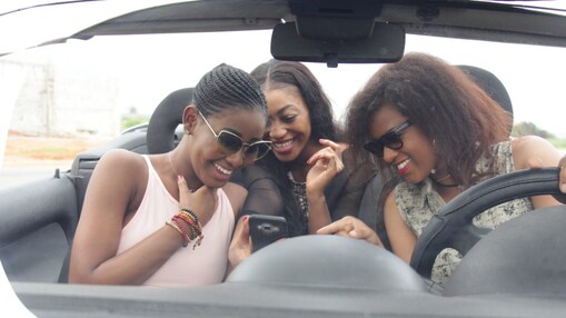 young women in car checking navigation on a smart phone